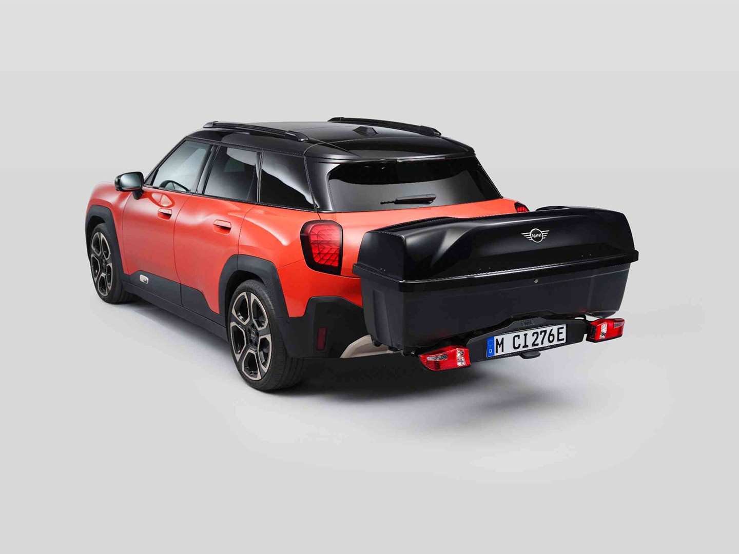 Rear side view of MINI Aceman in Nanuq White equipped with a MINI Rear Bike Rack and carrying the MINI Rear Box. 